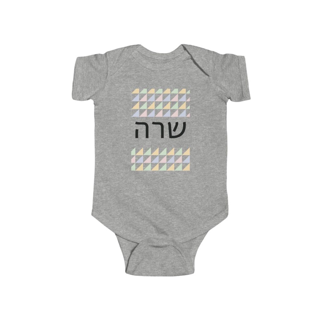 Front of the gray baby bodysuit with a sample Hebrew name and pale geometric pattern